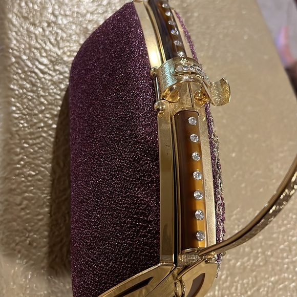 Elegant gold and maroon clutch with gold handle and gold chain